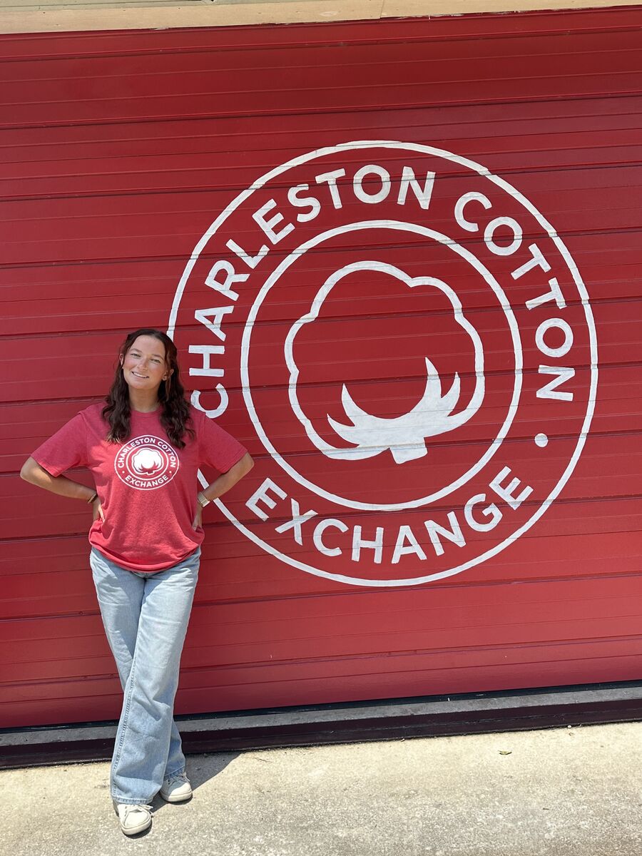 Peyton standing against the painted Charleston Cotton Exchange wall
