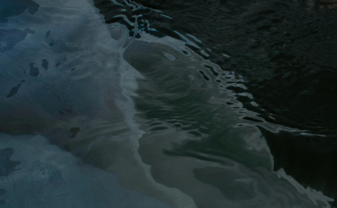 Abstract close-up of pale and dark water folding across the lake surface
